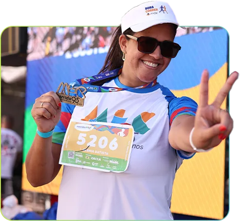 Participante com medalha fazendo sinal de paz